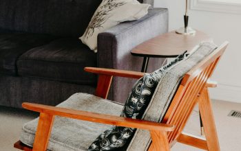 Wallpaper Gray Armchair with Brown Wooden Frame on Beige Area Rug