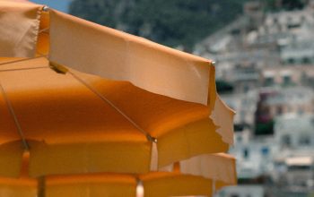 Wallpaper Aligned Orange Patio Umbrellas Near Mountain