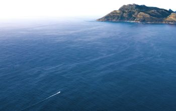 Wallpaper Sea Near Mountain During Daytime