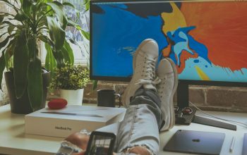 Wallpaper Person Using Smartphone While Resting Feet on Computer Desk
