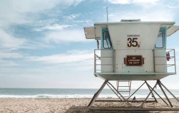 Wallpaper A Lifeguard Tower on a Beach with a Sky Background