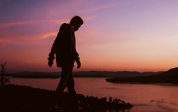 Wallpaper Silhouette of Man on Rock at Sunset