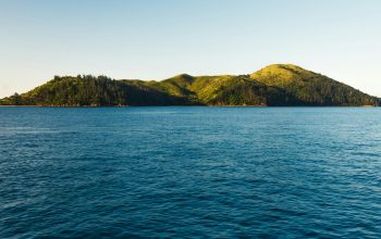 Wallpaper Green Mountain Beside Body of Water During Daytime