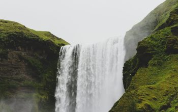 Wallpaper Waterfalls on Green Grass Covered Hill During Daytime
