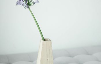 Wallpaper A White Table with a Flower in a Wooden Vase