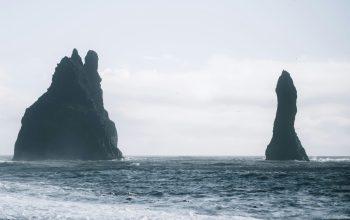 Wallpaper A Couple of Large Rocks Sticking Out of the Ocean