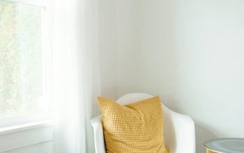 Wallpaper A White Chair with a Yellow Pillow Next to a Window