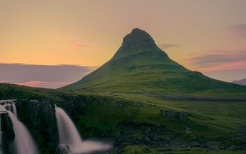 Wallpaper A Waterfall with a Mountain in the Background