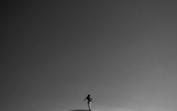 Wallpaper A Person Standing on Top of a Snow Covered Hill