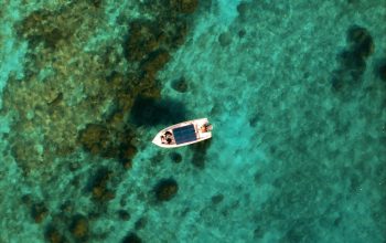 Wallpaper A Small Boat Floating on Top of Water