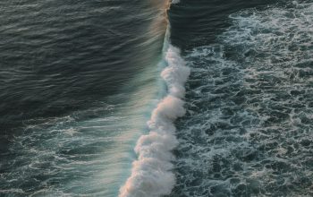 Wallpaper A Large Body of Water with Waves Coming to Shore