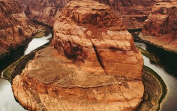 Wallpaper A River Running Through a Canyon Surrounded by Mountains