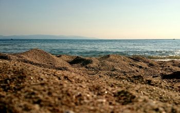 Wallpaper A Rocky Beach with Water in the Background