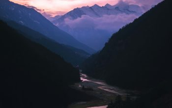 Wallpaper A River Running Through a Mountain Valley