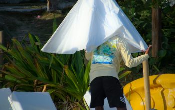 Wallpaper A Person Standing Under a White Umbrella on a Beach