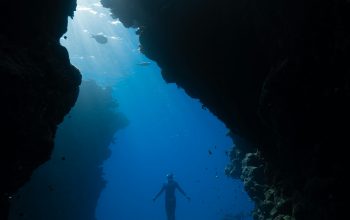Wallpaper A Person Swimming in a Cave