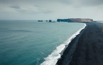 Wallpaper A Black Sand Beach on a Cloudy Day