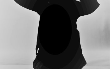Wallpaper A Black and White Photo of a Person Sitting on the Ground