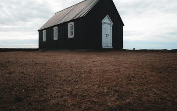 Wallpaper A Black Church with a Steeple and a White Door