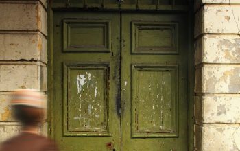 Wallpaper A Man Walking Past a Green Door