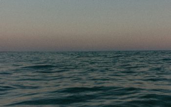 Wallpaper A Body of Water with a Moon in the Sky