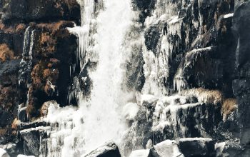 Wallpaper A Waterfall with Snow on the Rocks and Ice on the Ground