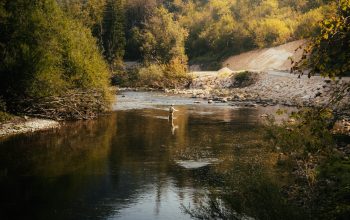Wallpaper A Man Standing in the Middle of a River