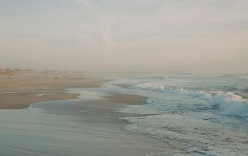 Wallpaper A Sandy Beach with Waves Coming In