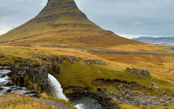 Wallpaper A Mountain with a Small Waterfall