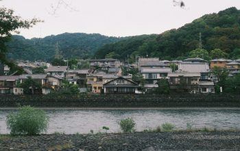 Wallpaper A Body of Water with Houses in the Background