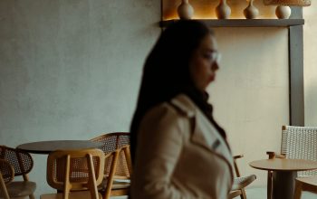 Wallpaper A Woman Standing in a Room Next to a Table