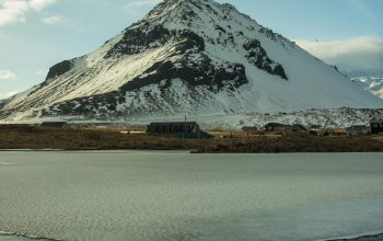 Wallpaper A Snow Covered Mountain with a Body of Water