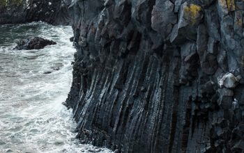 Wallpaper A Rocky Cliff with a Body of Water