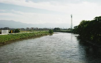 Wallpaper A River Running Through a Lush Green Countryside