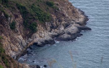 Wallpaper A Lighthouse on a Cliff Overlooking the Ocean