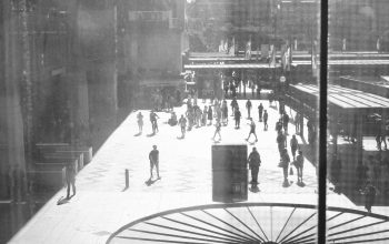 Wallpaper A Black and White Photo of People Walking on a Sidewalk