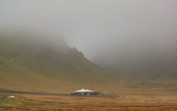 Wallpaper A Cabin Nestled in a Misty Landscape