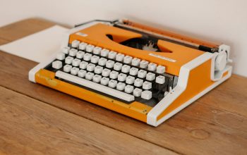 Wallpaper An Orange Typewriter on a Wooden Desk